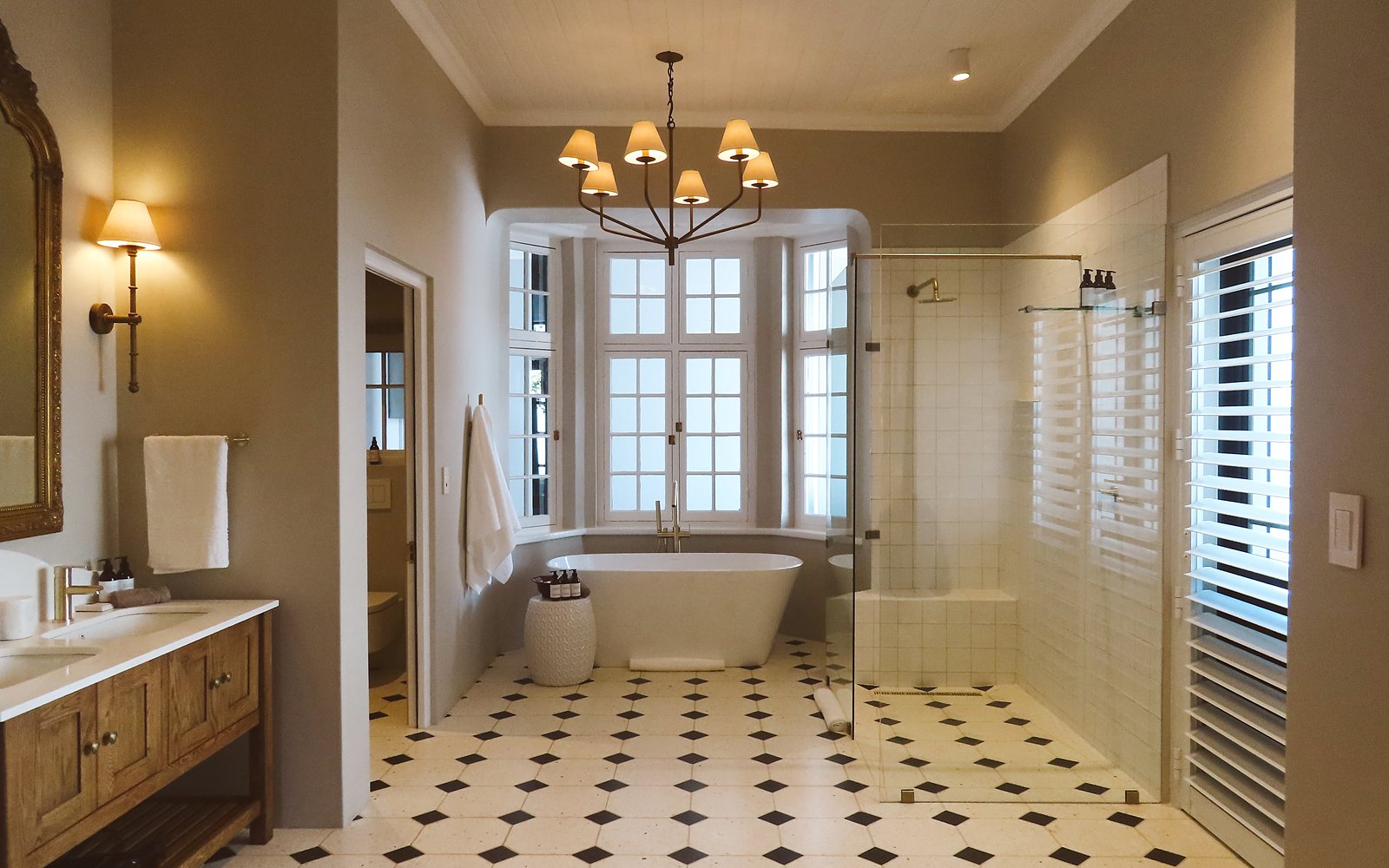 Suite bathroom with a freestanding bath under a bay window and a walk-in shower